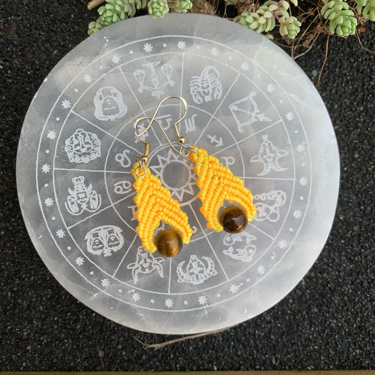 Boucles d’oreilles jaunes en macramé avec perle d’œil de tigre, accessoire spirituel favorisant la confiance et la joie de vivre.