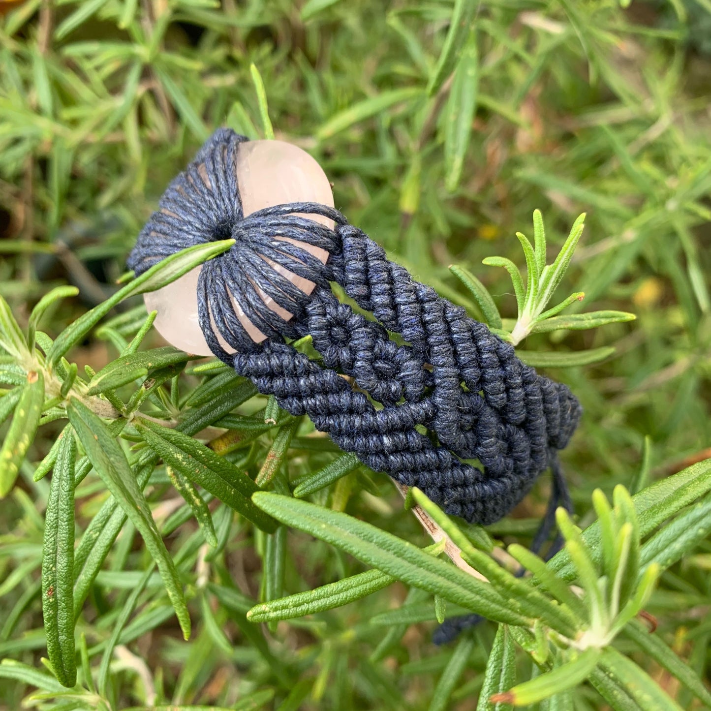 Détail tissage artisanal en micro-macramé bleu nuit et pierre naturelle en quartz rose pour bijou spirituel