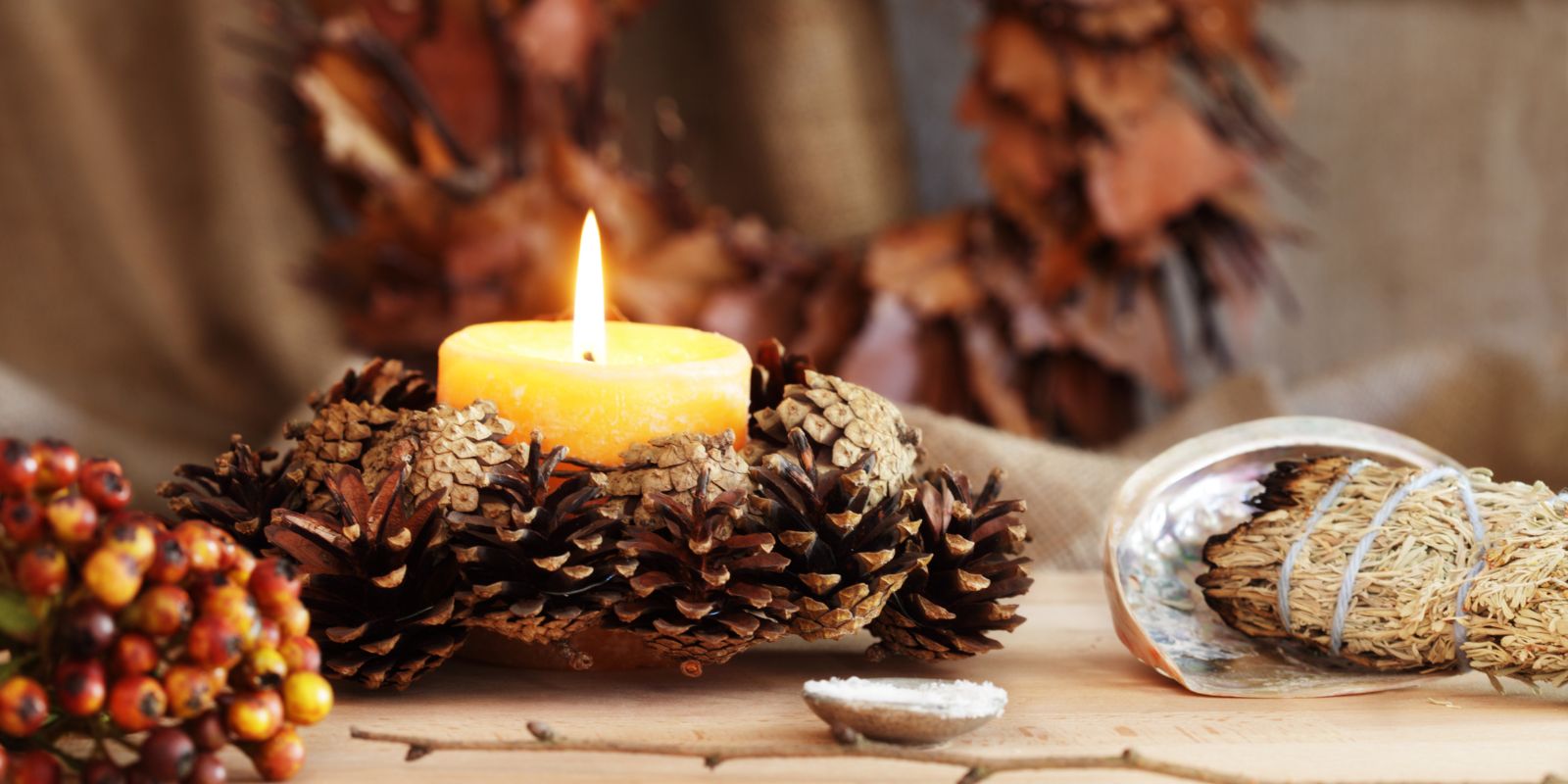 bougie dans une couronne de pommes de pin pour la boutique spirituelle en ligne Soeurs