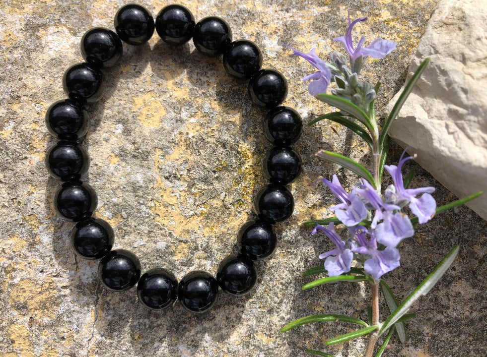 Composition d'un bracelet en obsidienne noire dans un environnement naturel et fleurit