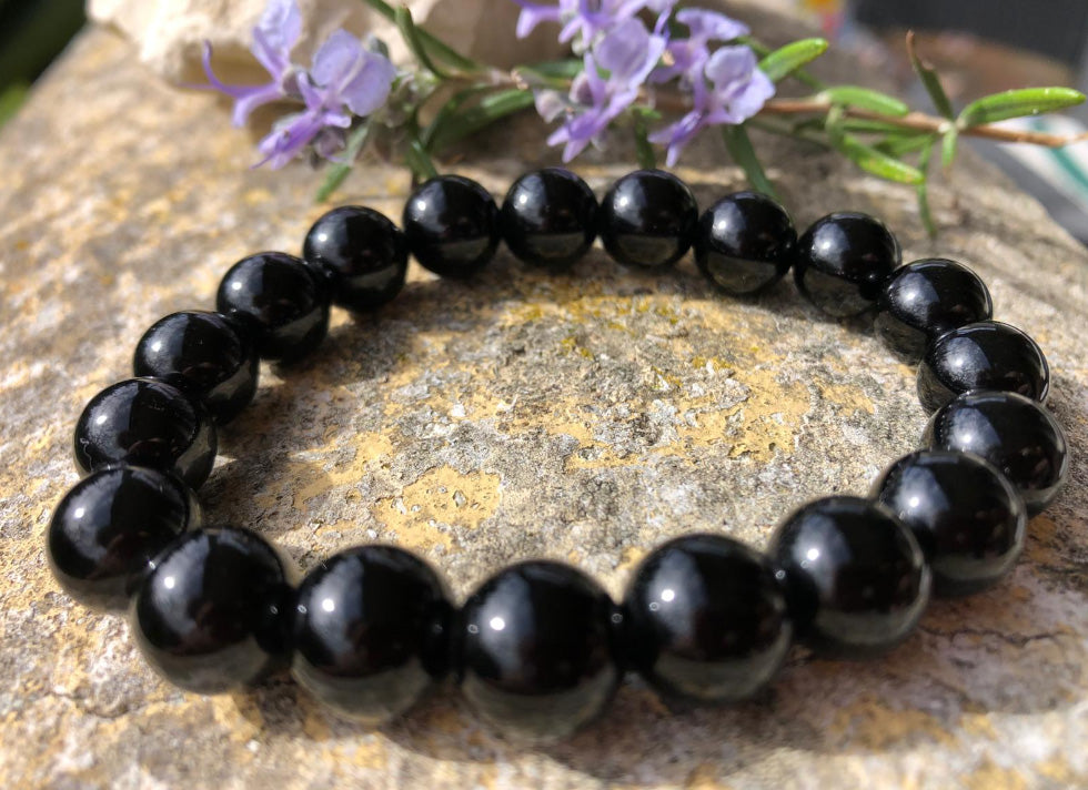 Bracelet en pierre naturelle Obsidienne Noire posé sur une pierre