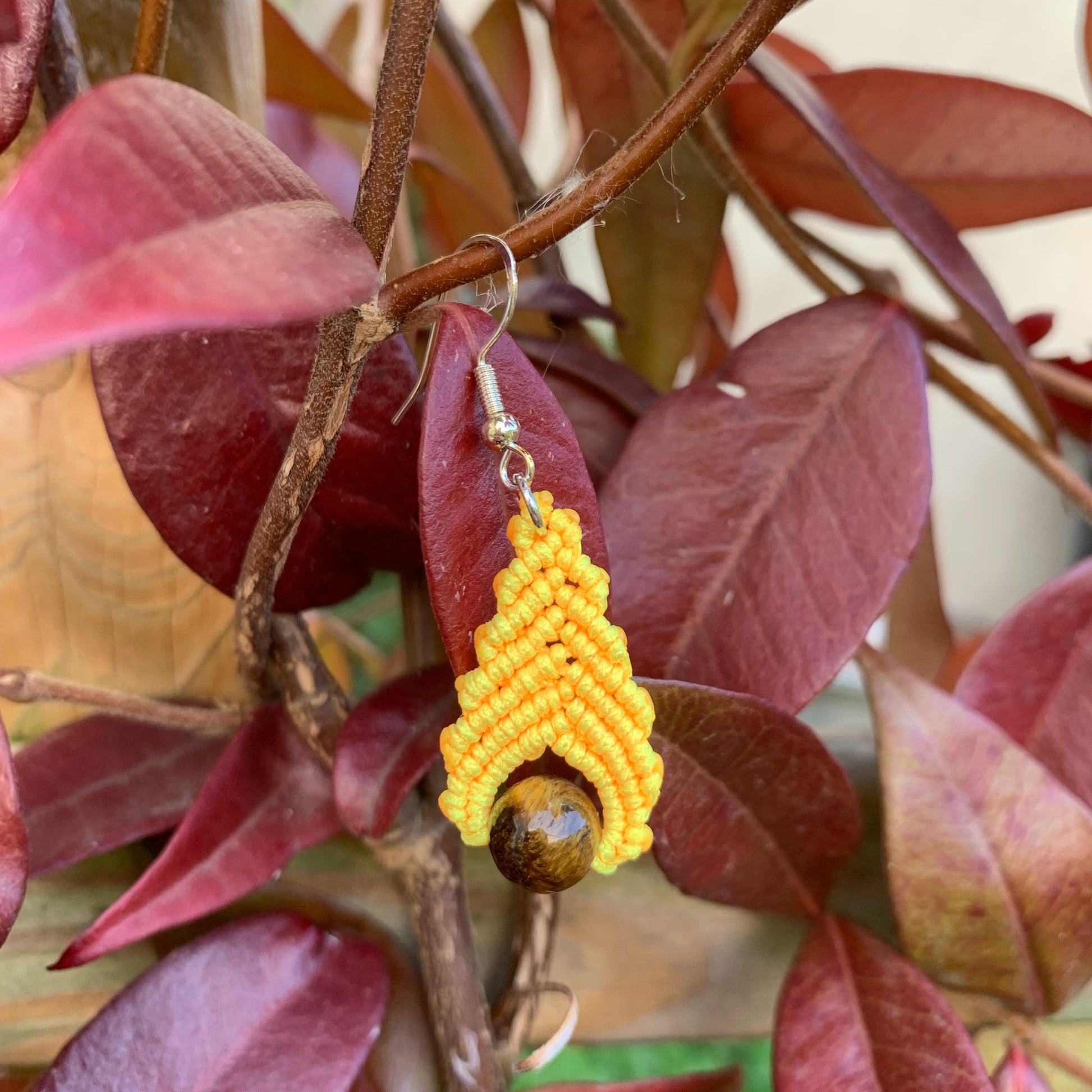 Bijou artisanal fait main en macramé jaune et pierre naturelle œil de tigre, pour un style bohème lumineux et équilibré.