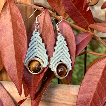 Boucles d’oreilles bohèmes vert d’eau en micro-macramé avec perle d’œil de tigre, bijou artisanal symbolisant la protection et l’équilibre.