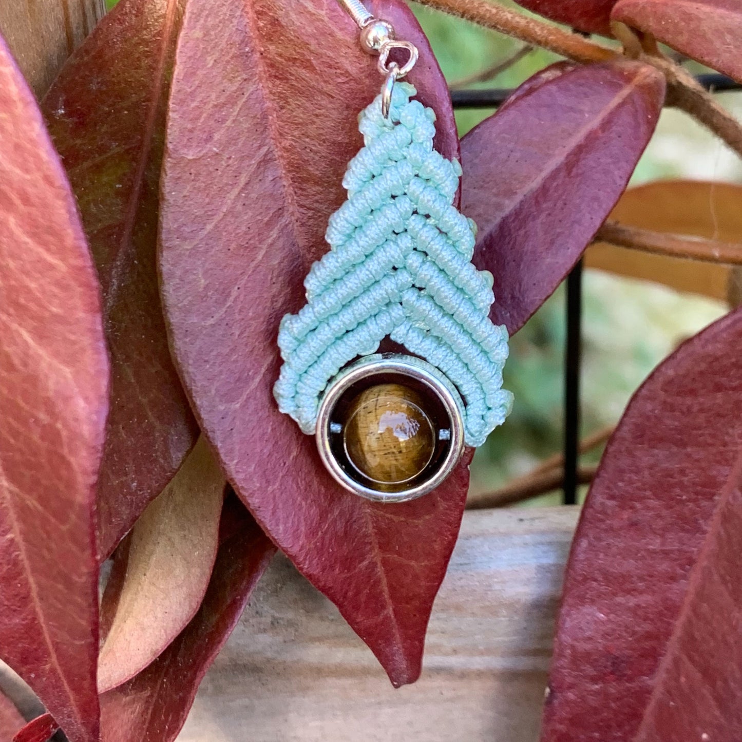 Bijou fait main en macramé vert d’eau et pierre naturelle œil de tigre, inspiré par la sérénité et la douceur des énergies apaisantes.