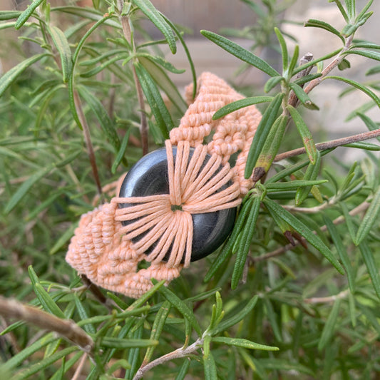 Bracelet énergétique micro-macramé saumon porté au poignet pour méditation et bien-être quotidien