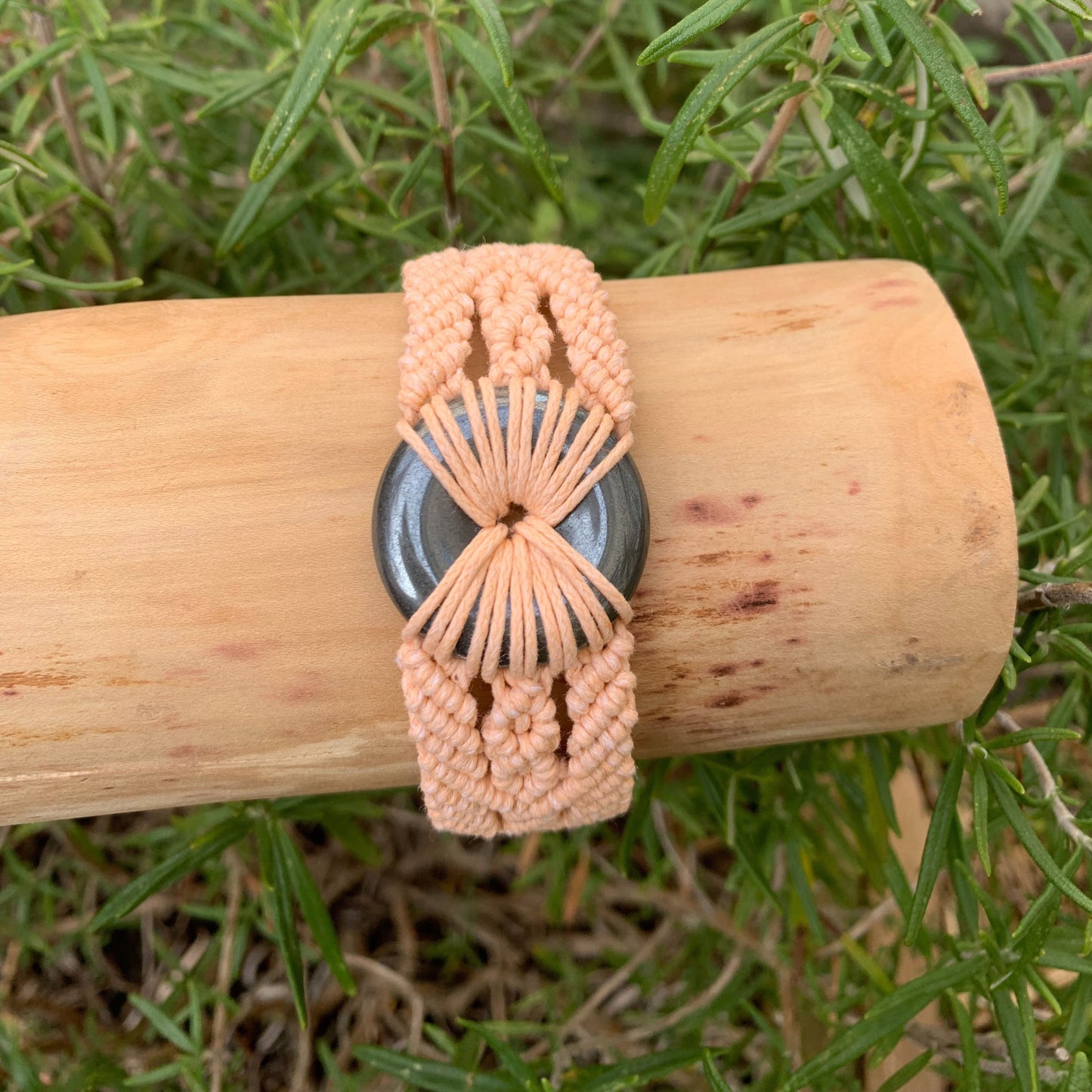 Gros plan de la pierre hématite ronde sur bracelet artisanal spirituel pour protection et harmonisation