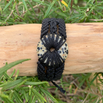 Gros plan du donut en pierre naturelle jaspe dalmatien sur bracelet spirituel pour équilibre émotionnel et harmonisation