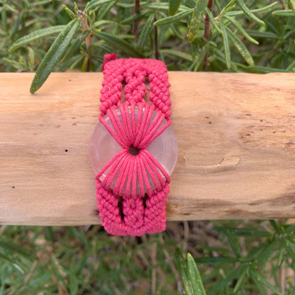 Gros plan du donut en pierre naturelle quartz rose sur bijou spirituel artisanal pour féminité et harmonie émotionnelle