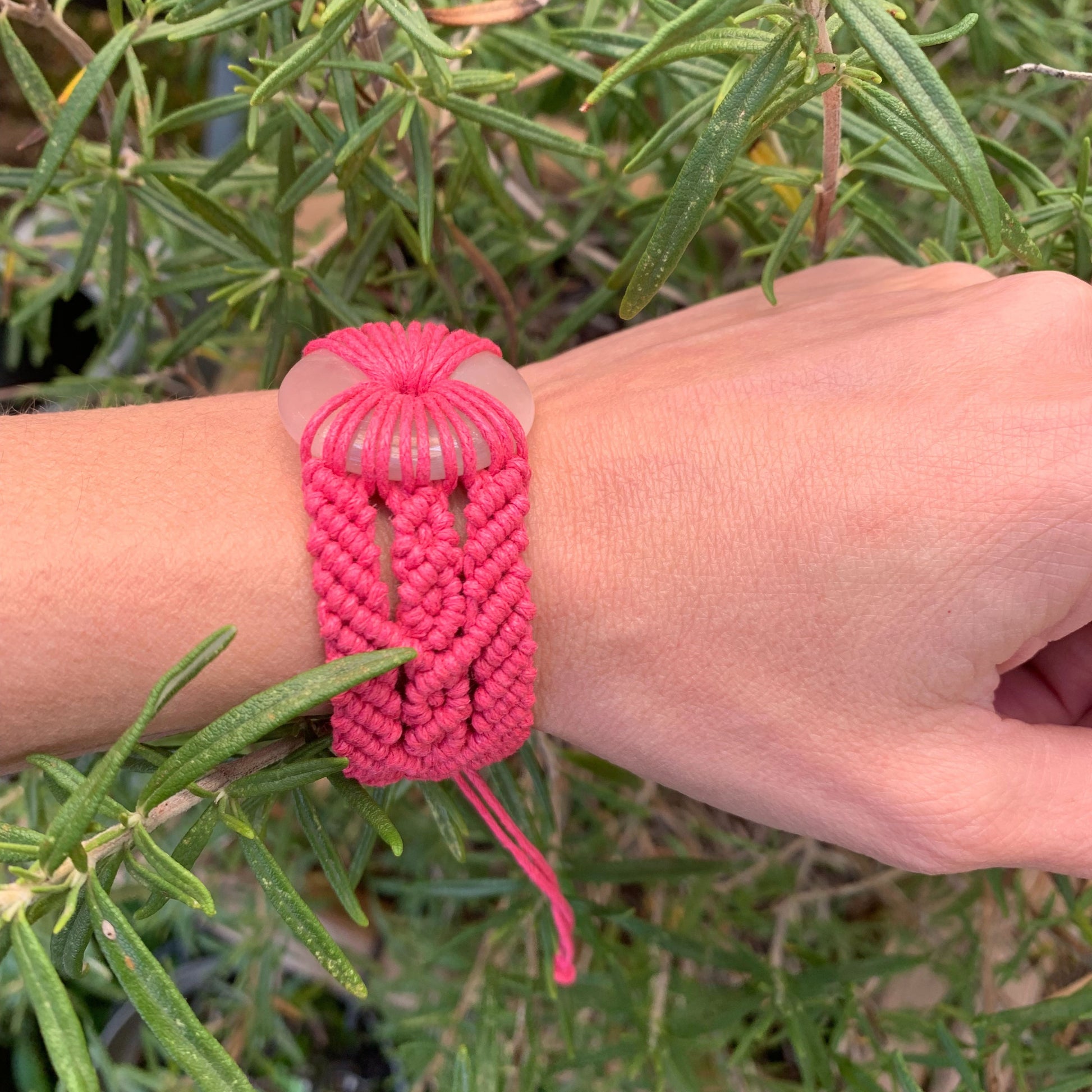 Détails artisanaux du tissage micro-macramé rose fuchsia avec quartz rose pour bijou énergétique et spirituel