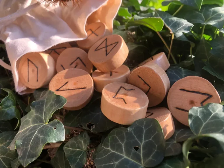 Runes du Futhark ancien gravées dans le bois, posées sur du lierre